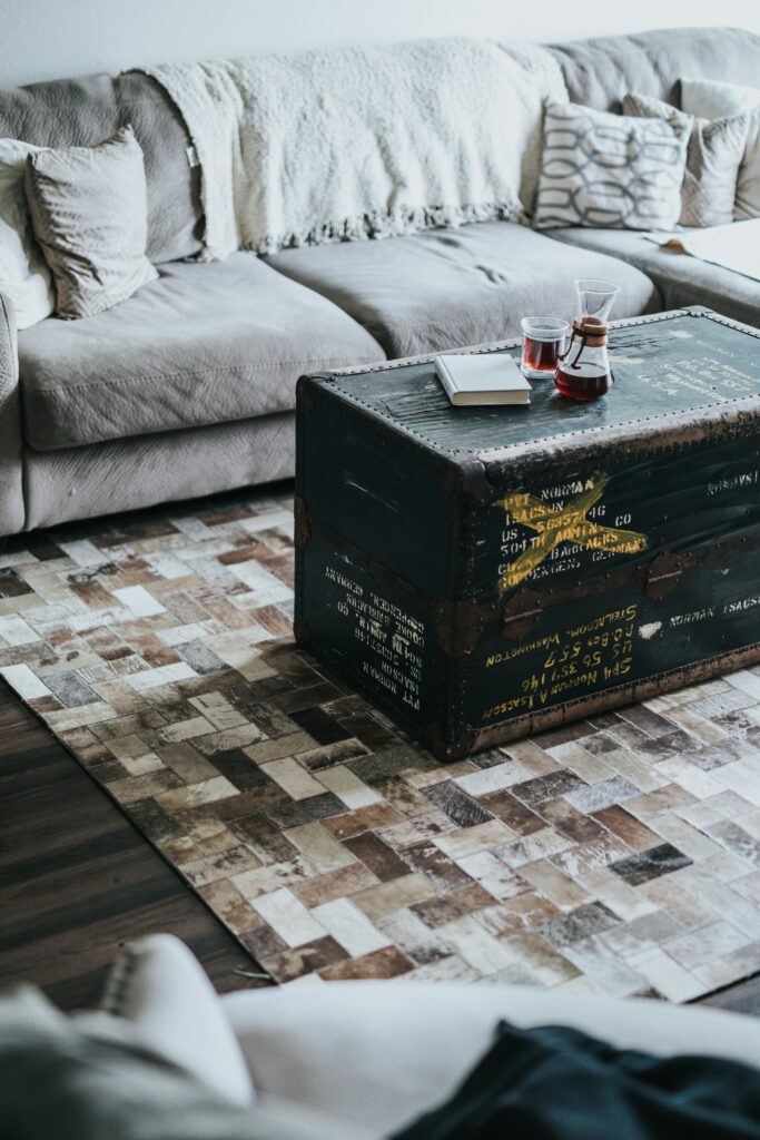 Living room with a vintage rug, wooden coffee table, and soft seating, combining rustic and contemporary design elements.
